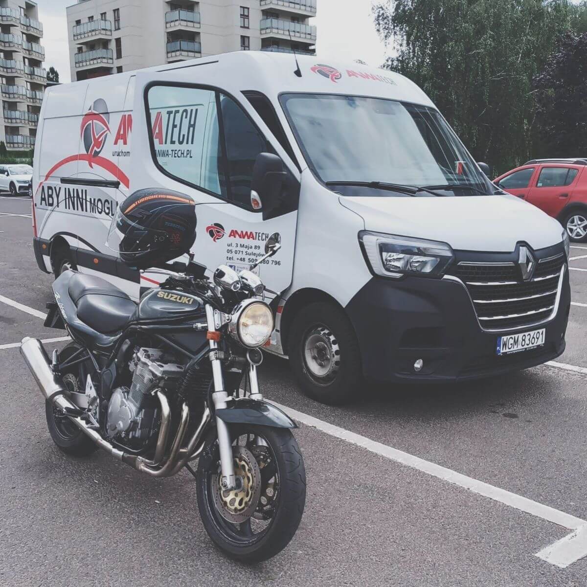 Motocykl Suzuki zaparkowany obok oklejonego vana serwisowego Anwa-Tech – zapowiedź praktycznego szkolenia z obsługi kół motocyklowych